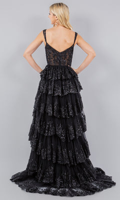 A woman stands facing away in the Cinderella Couture 8093J—a black, sleeveless, floor-length prom dress with layered ruffles and shimmering sequins—set against a plain gray background.