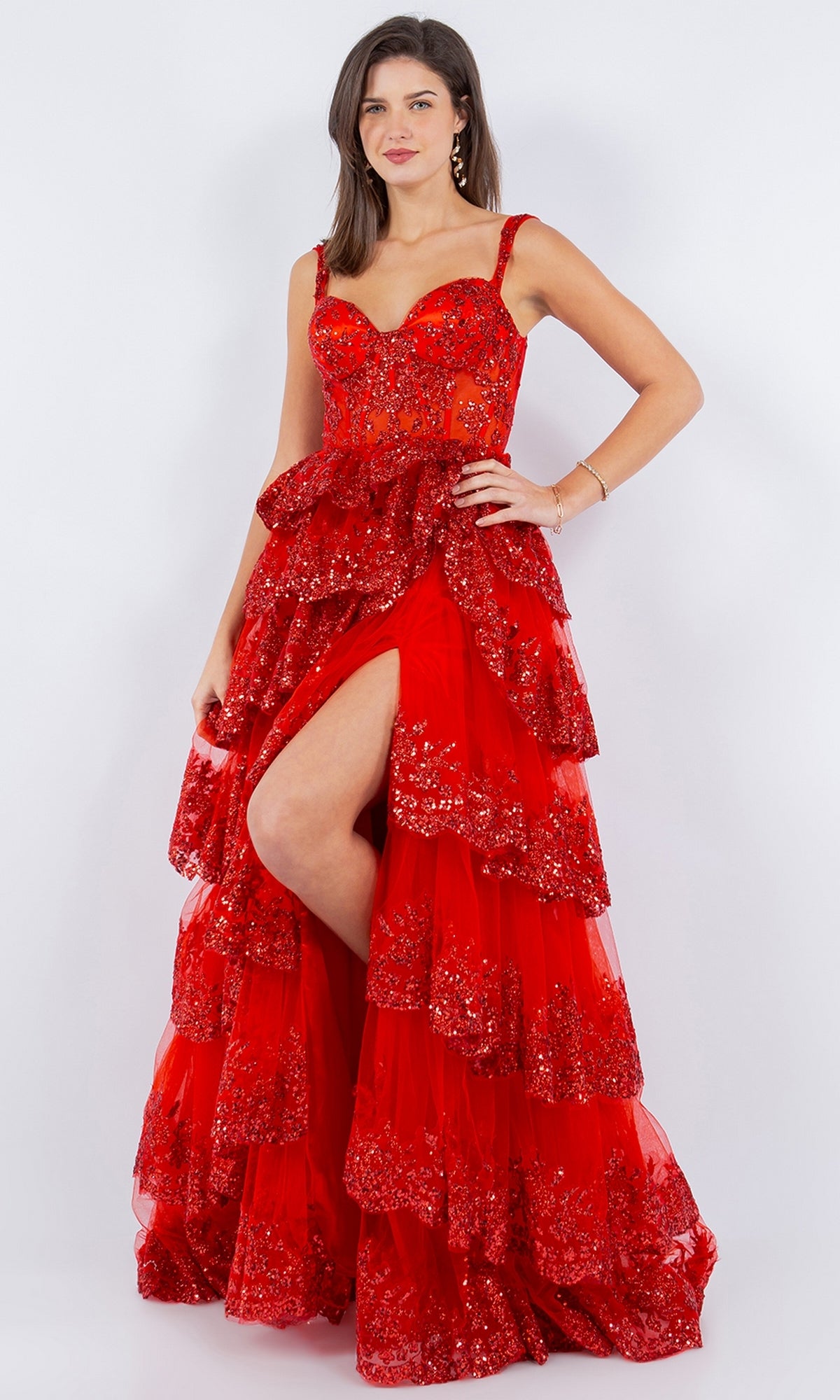 A woman models the Cinderella Couture 8093J Ruffled Tiered Prom Dress, featuring red sequin glitter, ruffled layers, and a thigh-high slit, against a plain white background.