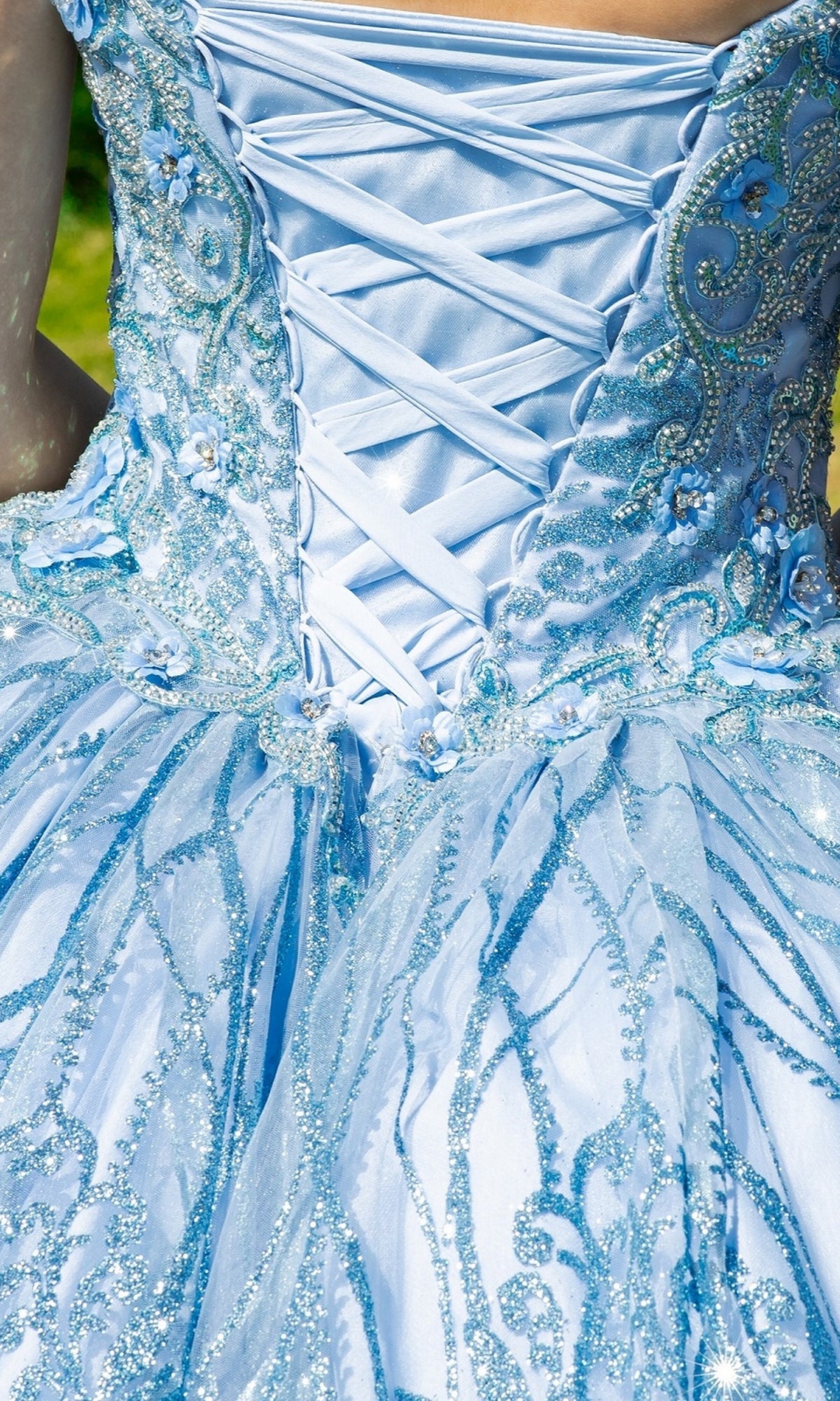 Close-up of the embroidered bodice on Quinceanera Ball Gown 8110J, showcasing intricate beadwork, glitter print details, and a delicate crisscross lace-up back.