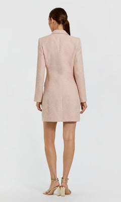 A woman stands facing away, wearing the Short Pink Wedding Guest Dress: Mac Duggal 81198 and beige heeled sandals against a plain white background.