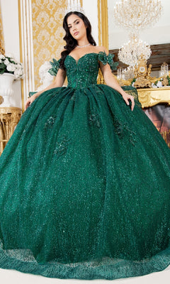 A woman wearing the Quinceanera Ball Gown 8120J poses indoors in a decorated room with gold accents, a chandelier, and an ornate fireplace in the background.