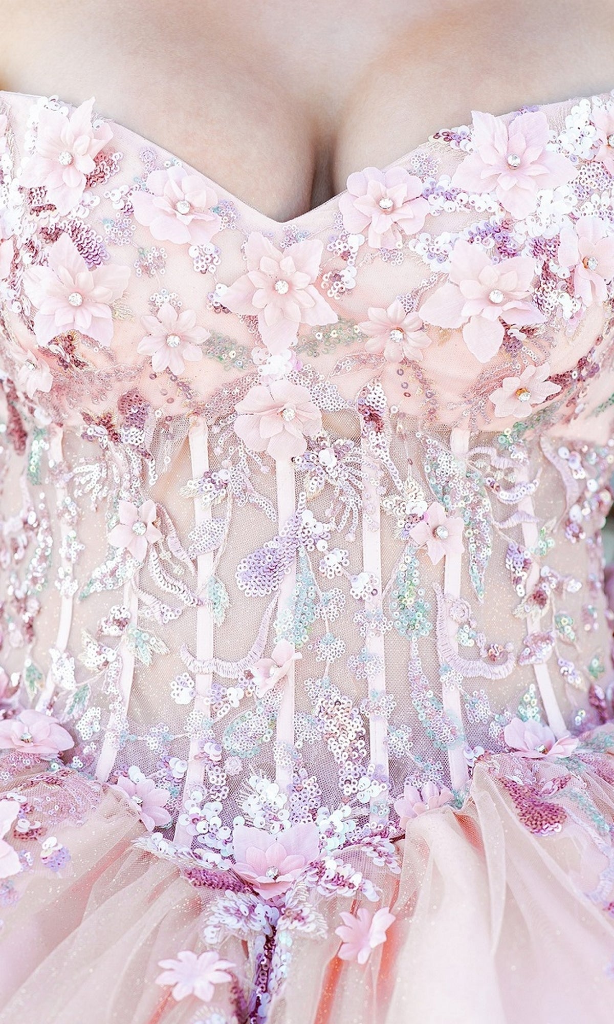 Close-up of Quinceanera Ball Gown 8125J in pink, showcasing floral embroidery, intricate lace, beadwork, 3D flower appliqués, and a corset lace-up bodice.