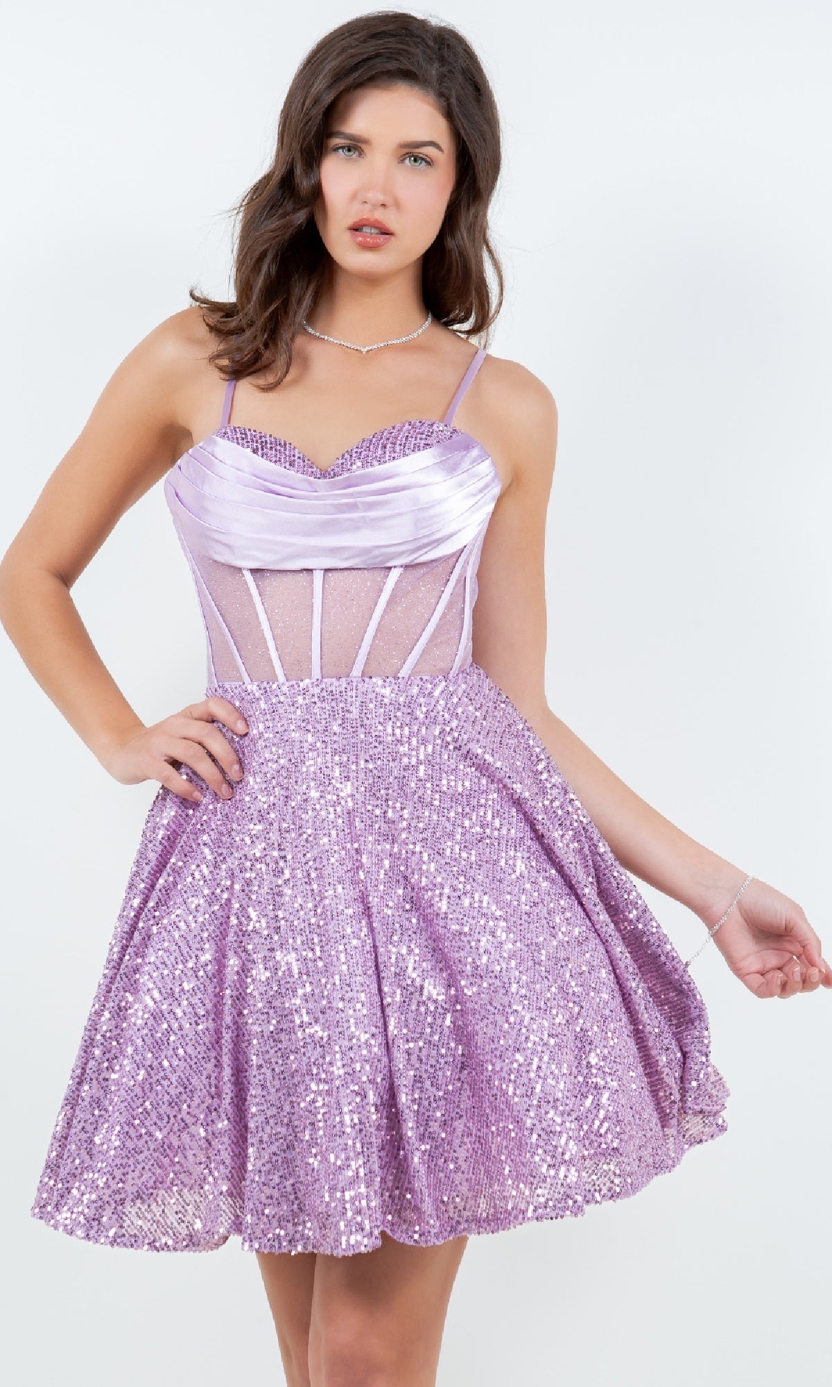 A woman poses in the Cowl-Neck Short Sequin Homecoming Dress 8126J, a sleeveless lilac dress with spaghetti straps, fitted bodice, and flared skirt, set against a plain white background.