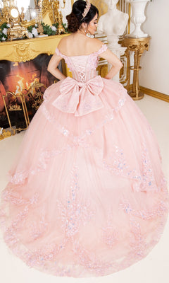 Woman wearing the Cinderella Couture 8160J pink off-the-shoulder quinceañera ball gown with floral lace appliques stands in front of a fireplace and ornate gold décor, facing away from the camera.