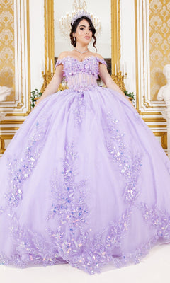 A young woman stands in an ornate, gold-accented room wearing the Cinderella Couture 8160J quinceanera dress—an off-the-shoulder lavender ball gown with floral embroidery and a chandelier overhead.