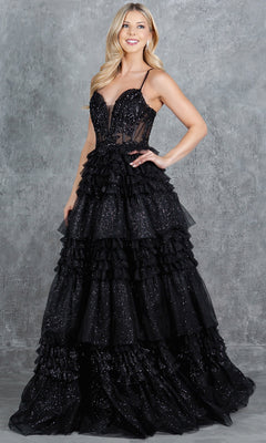 A woman smiles at the camera in the Glitter Prom Ball Gown: Cinderella Couture 8163J, featuring a beaded corset bodice and tiered black skirt, standing against a gray textured background.