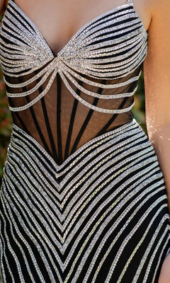 Close-up of a person wearing the Cinderella Couture 8169J long pageant gown, featuring black fabric with sheer panels and geometric silver sequin patterns forming elegant lines and curves.