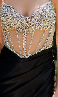 A close-up of a person wearing the Beaded-Bodice Prom Gown: Cinderella Couture 8171J, featuring a sheer bodice adorned with silver rhinestones and intricate black beadwork.