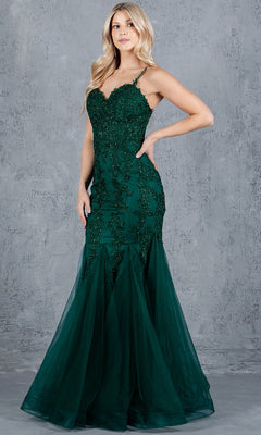 A woman stands before a gray textured wall in the Lace-Up Long Prom Dress: Cinderella Couture 8175J—a dark green mermaid gown with beaded accents and tulle at the hem.