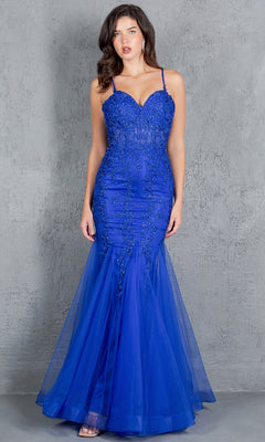 A woman wears the Lace-Up Long Prom Dress: Cinderella Couture 8175J, a fitted royal blue mermaid gown with beaded details and thin straps, posing against a textured gray background.