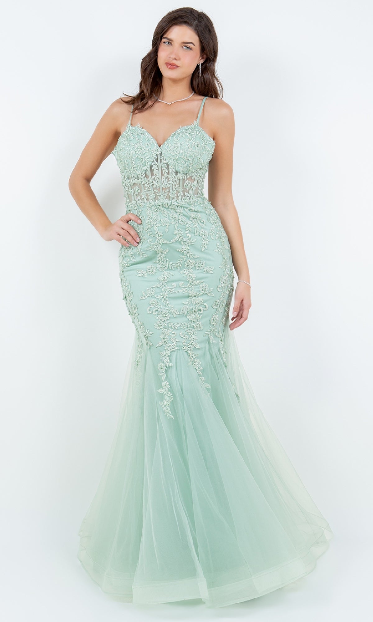 A woman wears the Lace-Up Long Prom Dress: Cinderella Couture 8175J—a fitted mint green gown with beaded lace appliqué and thin straps—against a plain white background.