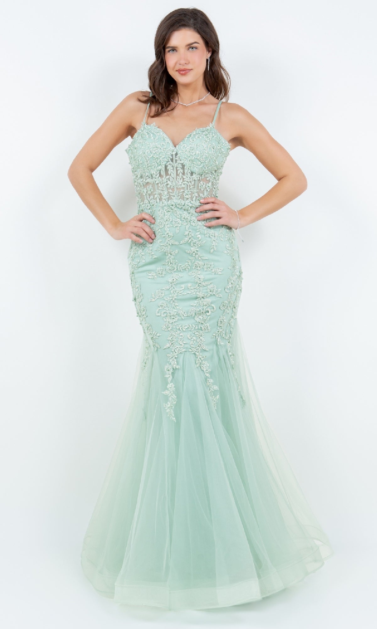 A woman models the Lace-Up Long Prom Dress: Cinderella Couture 8175J, a light green, floor-length mermaid gown with beaded lace applique and sheer details, set against a plain white background.
