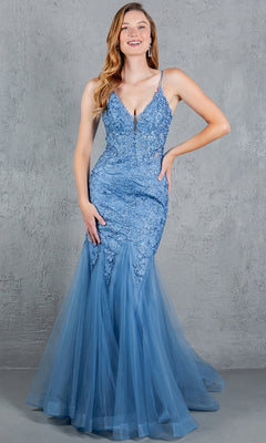 A woman poses by a gray textured wall in the Beaded Long Prom Dress: Cinderella Couture 8178J, a sleeveless blue gown with beaded embroidery, fitted bodice, and flared lace and tulle skirt.