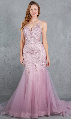 A woman in the Cinderella Couture 8178J Beaded Long Prom Dress—sleeveless, floor-length, pink with lace and tulle and delicate beaded embroidery—stands before a gray textured backdrop.