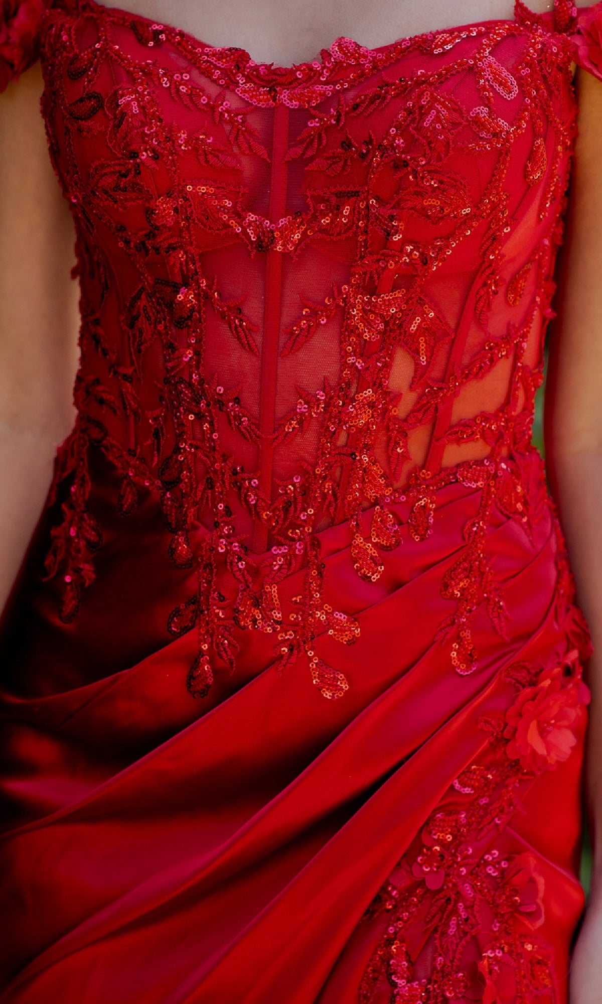 Close-up of a person wearing the Sparkly Long Prom Dress: Cinderella Couture 8181J in red, featuring an off-the-shoulder design with intricate sequin and lace embroidery on the bodice and draped satin fabric.