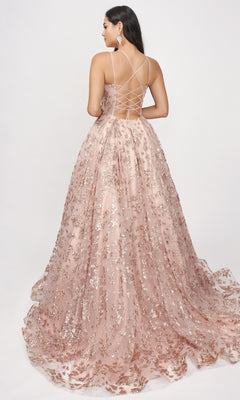 A woman models the Nina Canacci 8246 Rose Gold Prom Ball Gown, featuring silver sequins and a lace-up back, in a floor-length design against a plain white background.