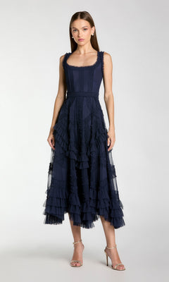 A woman wears the Mac Duggal 8250 Ruffled Midi Wedding Guest Dress in navy blue with silver heels, posing against a plain light background.