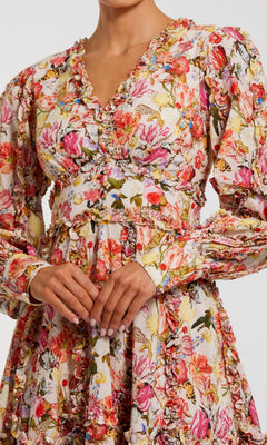 Someone wears the Mac Duggal 8261 Micro-Ruffle Wedding-Guest Dress—a long-sleeved, V-neck style with a colorful floral print and ruffled trim, ideal for wedding guests seeking a standout floral look.