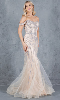 A woman models the Long Beaded Prom Dress: Cinderella Couture 8271J, an elegant light beige off-the-shoulder gown with silver embellishments, standing against a textured gray background.
