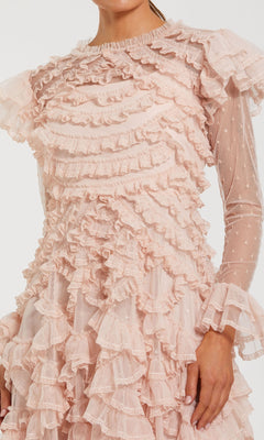 Someone wears the Mac Duggal 8274 Long Sleeve Ruffle Formal Dress, a sheer pink gown featuring layers of ruffles and a subtle polka dot pattern.