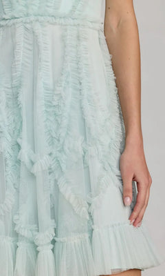 A close-up of a person in the Mac Duggal 8289 Short Ruffled Wedding Guest Dress, featuring light blue tulle ruffles, highlighting the lower torso and part of an arm—ideal for wedding guests.