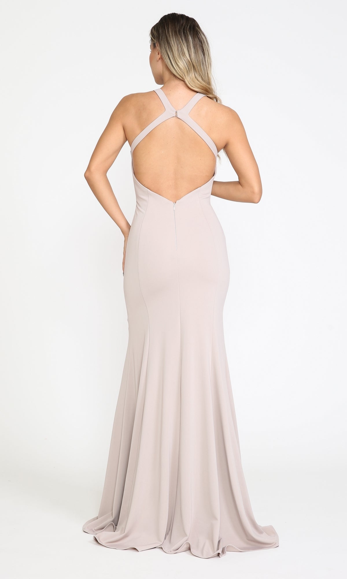 A woman stands with her back to the camera against a plain white background, wearing the Simple Sleeveless Long Jersey Prom Dress 8298 in light beige, featuring a floor-length open back with criss-cross straps.
