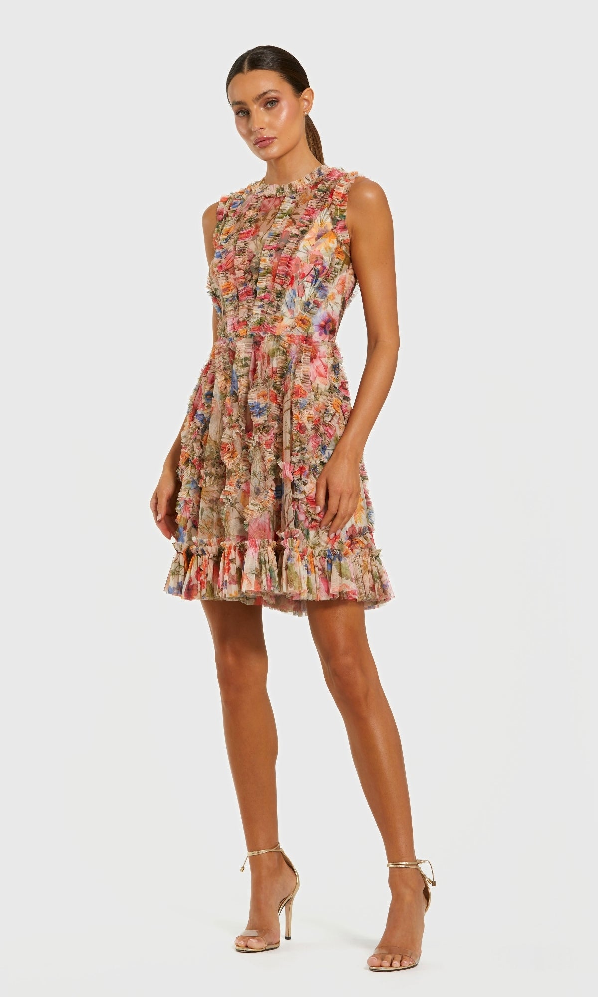 A woman wears the Mac Duggal 8307 high-neck print wedding-guest dress with ruffle detailing and nude high heel sandals, standing against a plain white background.
