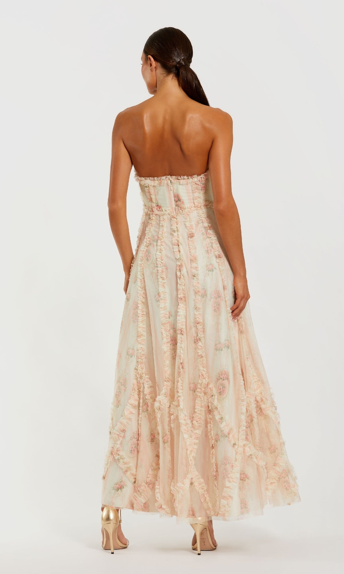 A woman stands with her back to the camera in the Mac Duggal 8308 Strapless Print Midi Party Dress and gold high-heeled sandals, set against a plain background.