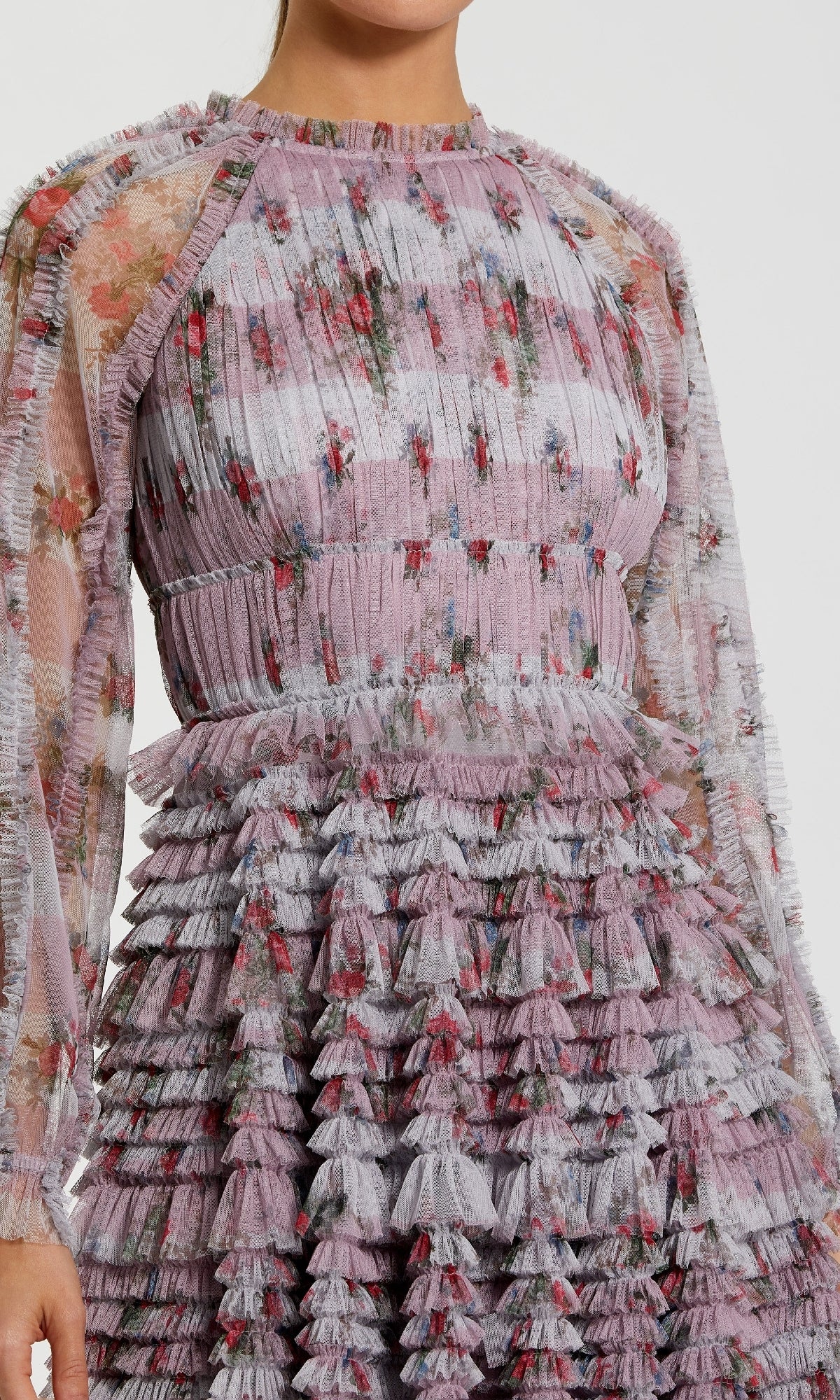 Close-up of a floral dress with ruffled layers on a plain background
