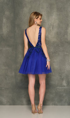 A woman faces away, wearing the A-Line Short Homecoming Dress H341 in royal blue with a beaded bodice, sleeveless design, nude heels, and silver accessories against a textured gray background.