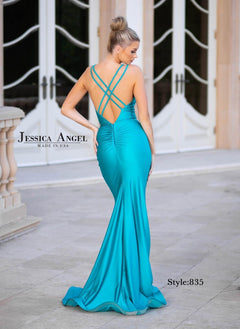 A woman stands outdoors near arched double doors, wearing the Jessica Angel 835 Cut-Out Long Mermaid Prom Dress in turquoise with crisscross straps and an open back. "Jessica Angel Style: 835" appears on the image.