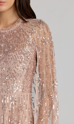 Close-up of a woman wearing the Mac Duggal 8415, a long formal dress featuring light pink sequins and bead embellishments in vertical and star patterns.