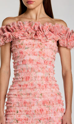 A woman in the Mac Duggal 8432 Midi Party Dress—a beautiful off-the-shoulder pink party dress adorned with ruffle tiered layers and a delicate floral pattern, making it the perfect pink floral midi dress for special occasions.