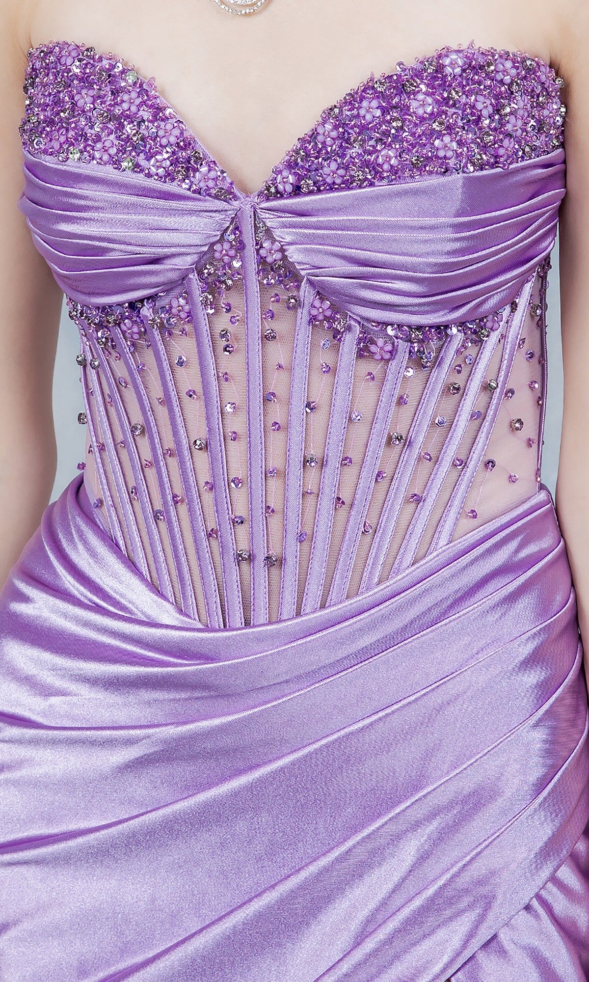 A close-up of the Cinderella Couture 8449J long prom dress in lavender, featuring a strapless sheer beaded bodice and ruched satin fabric—an elegant formal gown ideal for special occasions.