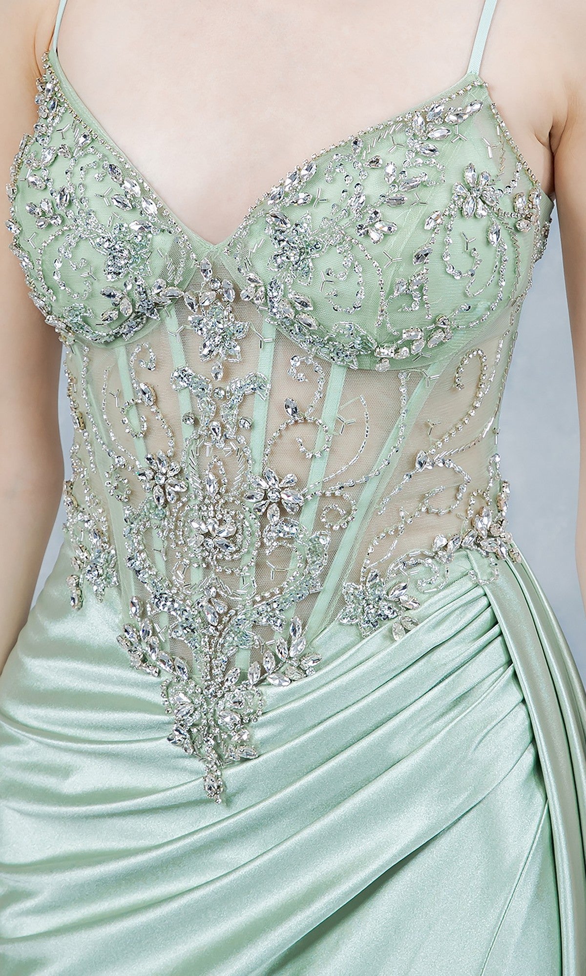 Close-up of the Cinderella Couture 8483J long prom dress in light green satin, showcasing intricate beaded embroidery and delicate floral details on its sheer corset bodice.