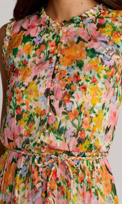 A close-up of the Mac Duggal 8500 Tea-Length Party Dress, featuring a colorful floral pattern, fabric-covered buttons, a braided waist tie, and a sleeveless design.