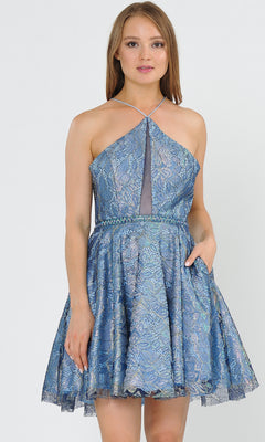 A woman faces forward in the Glitter-Mesh Short A-Line Homecoming Dress 8506, featuring a blue glitter-mesh fabric, flared skirt, mesh panel detail, and her right hand in her pocket.