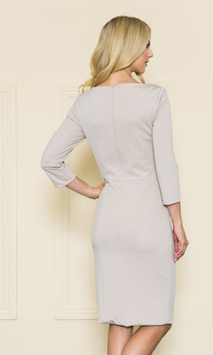 A woman with long blonde hair faces away, wearing the Classy Knee-Length Career Dress 8526 in light beige, featuring a fitted silhouette and three-quarter sleeves.