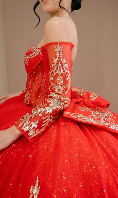 A woman wearing the Quinceanera Dress 8545JQ by Cinderella Couture, a red ball gown with gold embroidery, beaded sequins, off-the-shoulder sweetheart neckline, voluminous skirt, and detailed sleeves.