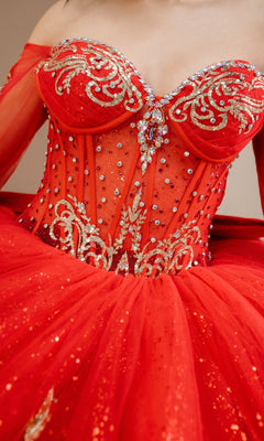 A close-up of a person wearing the Quinceanera Dress 8545JQ By Cinderella Couture, a red ball gown with an off-the-shoulder sweetheart neckline, gold embroidery, and sparkling beaded sequin embellishments.