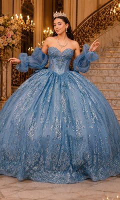 A person wearing a dusty blue Cinderella Couture 8565JQ quinceanera dress with off-the-shoulder puff sleeves, silver embellishments, and a tiara.