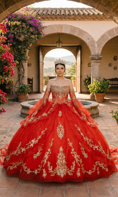 A woman in the red Quinceanera Dress 8575JQ by Cinderella Couture stands in a courtyard adorned with flowers and archways, with mountain views in the background, wearing a crown.
