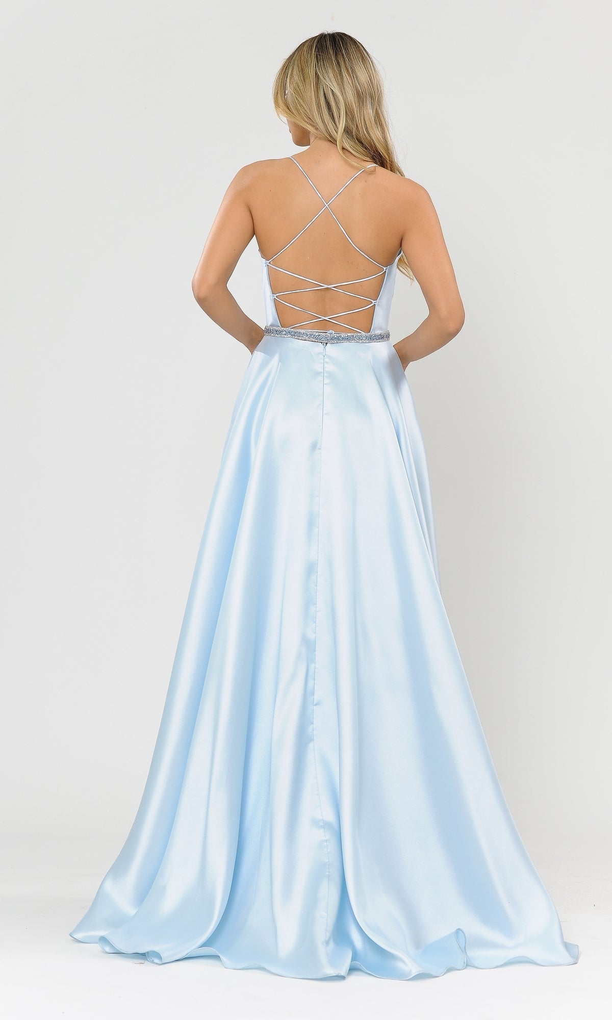 Woman wearing the Scoop-Neck Long A-Line Prom Dress with Pockets 8684 in light blue satin, featuring a crisscross open back, stands facing away from the camera against a plain white background.
