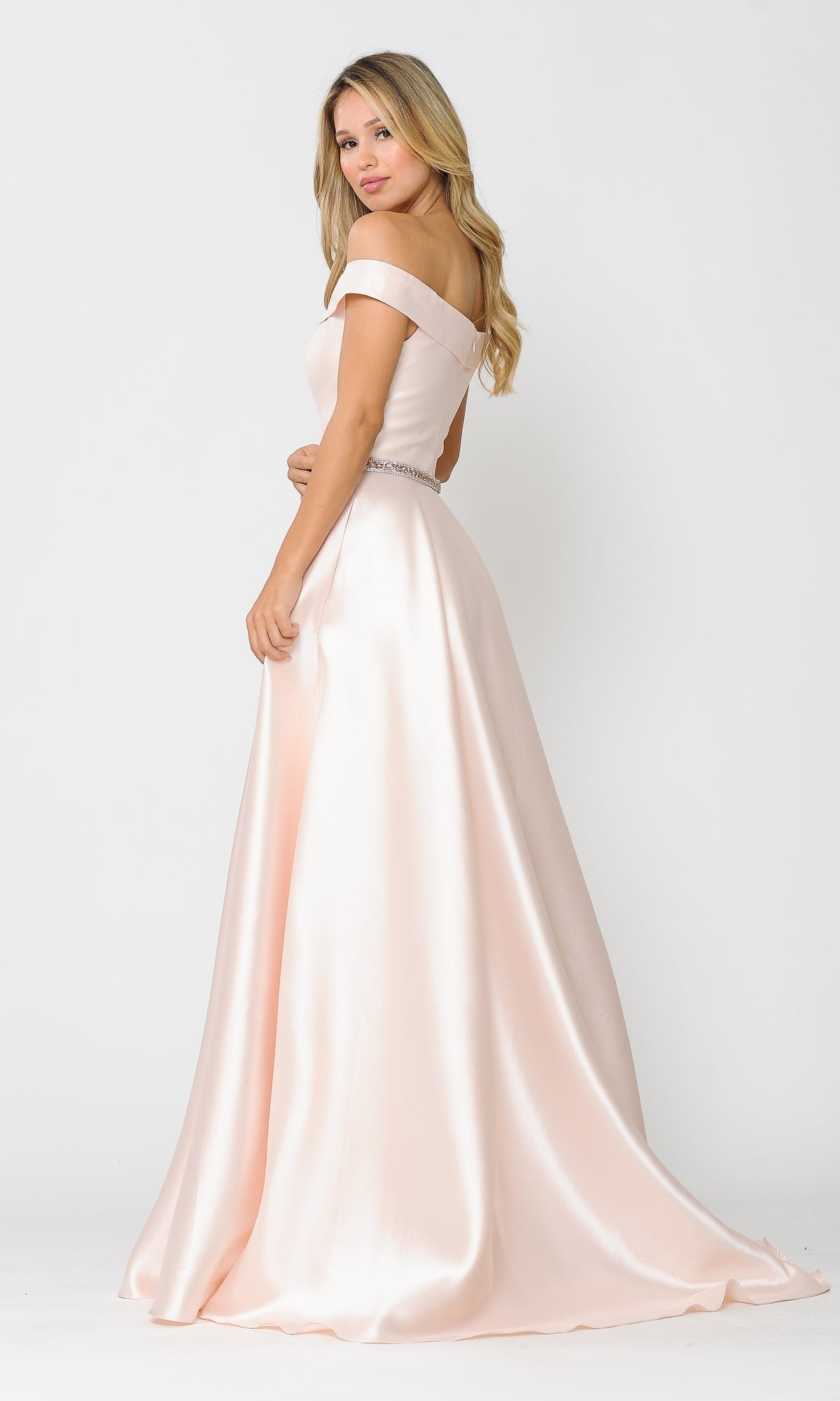 A woman stands against a plain white background wearing the Off-the-Shoulder Long Prom Gown with Pockets 8686 in light pink, looking over her shoulder.
