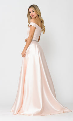 A woman stands against a plain white background wearing the Off-the-Shoulder Long Prom Gown with Pockets 8686 in light pink, looking over her shoulder.
