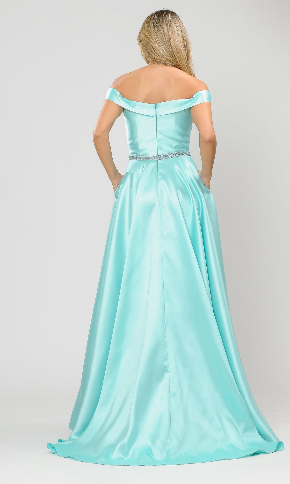 A woman in the Off-the-Shoulder Long Prom Gown with Pockets 8686, featuring a light blue hue, fitted bodice, jeweled waistband and full skirt—an elegant and affordable choice for special occasions.