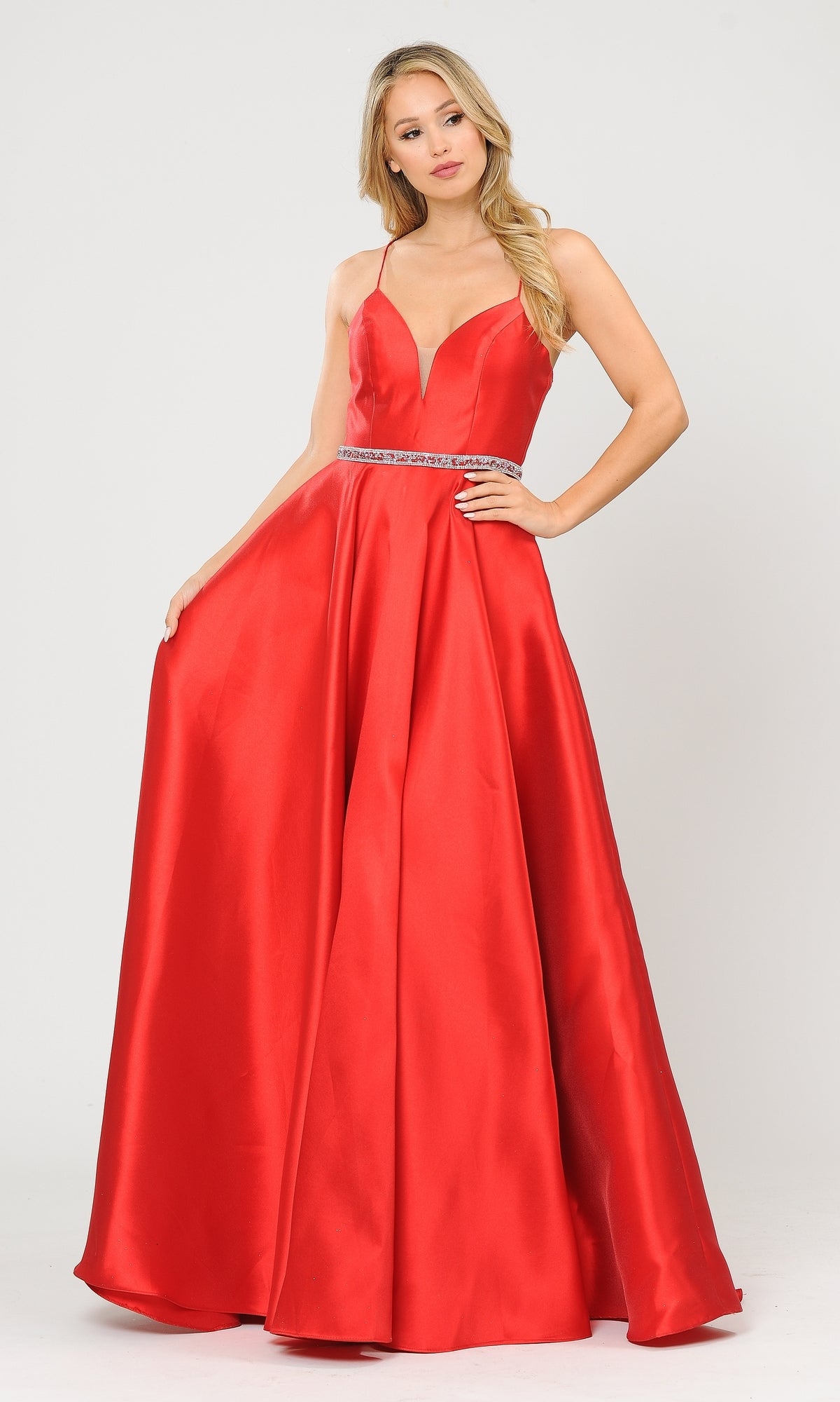 A woman poses against a white background in the Strappy-Back Long Mikado A-Line Prom Dress 8688 in red, featuring a floor-length, sleeveless design with a deep V neckline, thin straps, and a jeweled waist belt.