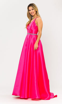 A woman in the Long A-Line Mikado Prom Gown 8690 with Pockets—sleeveless, floor-length, bright pink with a V-neckline and jeweled waistband—smiles against a white background.