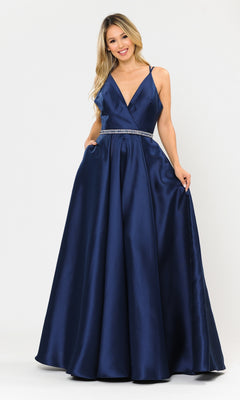 A woman models the Long A-Line Mikado Prom Gown 8690 with pockets, featuring a sleeveless deep blue design, V-neckline, rhinestone belt, and full skirt, against a plain white background.