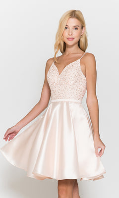 A woman wears the Short A-Line Homecoming Dress with Pockets 8694 in blush, featuring a sleeveless, fitted embellished bodice and flared satin skirt, standing against a plain white background.